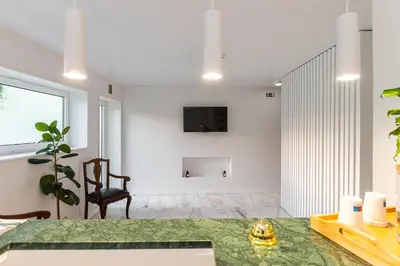 a living room with a table and a tv on a wall at Soho Porto in Porto