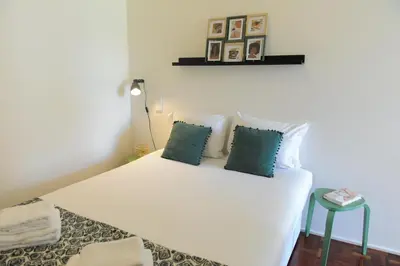 a bedroom with a white bed with blue pillows at Porto City Center Mercado do Bolhão Prime location jesuína e as 3 janelas in Porto