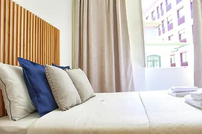 a bedroom with a bed with blue and white pillows at Oporto Sweet Downtown 5 in Porto