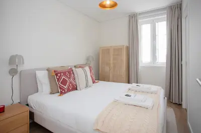 a bedroom with a white bed and a window at Liiiving in Porto - Downtown Quiet House in Porto