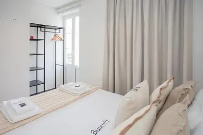 a white bedroom with a large bed and a window at Liiiving in Porto - Downtown Quiet House in Porto