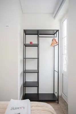 a room with a black book shelf next to a bed at Liiiving in Porto - Downtown Quiet House in Porto