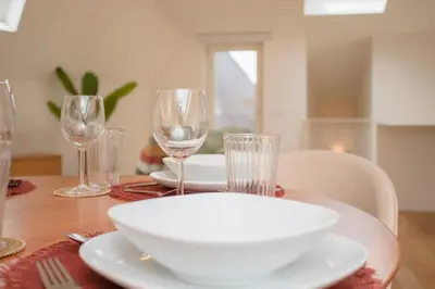 a table with a white plate and glasses on it at Liiiving in Porto - Cedofeita Green Terrace in Porto