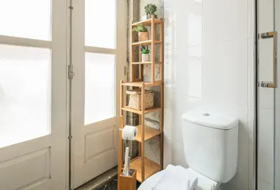 a bathroom with a toilet and a book shelf at Stay in Apartments - S. Bento in Porto