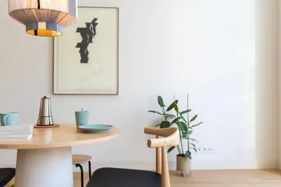 a kitchen with white cabinets and a counter with stools at Mouzinho 32 in Porto