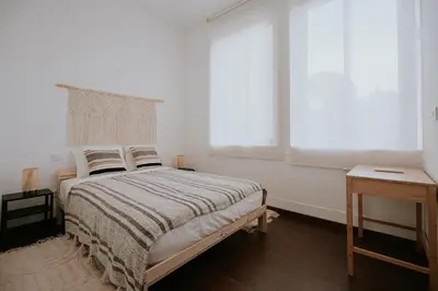 a white bedroom with a bed and a window at Porto Hostel Cúpula in Porto