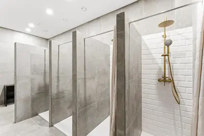 a walk in shower in a bathroom with gray walls at Porto Hostel Cúpula in Porto