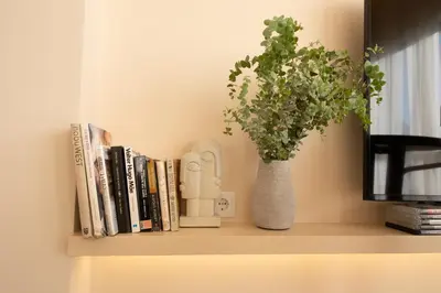 a shelf with books and a vase with a plant at Stylish Downtown Loft in Porto