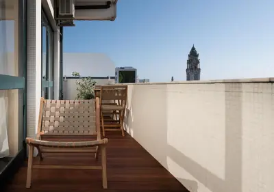 a balcony with chairs and a view of a building at Stylish Downtown Loft in Porto