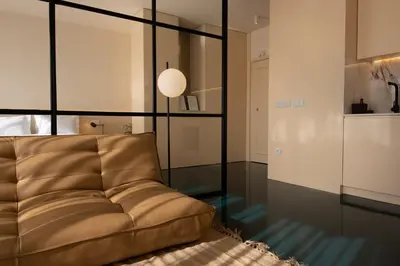 a living room with a couch and a glass wall at Stylish Downtown Loft in Porto