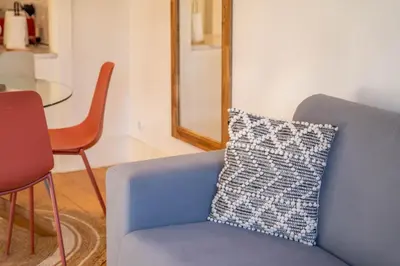 a blue chair with a pillow in a room at Historical Downtown Retreat Duplex by LovelyStay in Porto