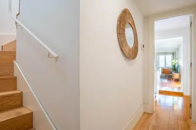 a hallway with stairs and a mirror on the wall at Historical Downtown Retreat Duplex by LovelyStay in Porto