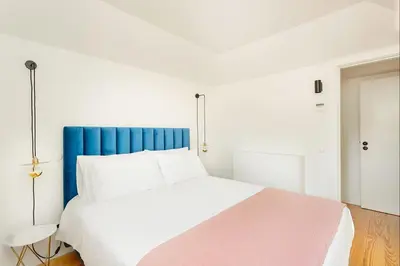 a white bed with a blue headboard in a room at Historical Downtown Retreat Duplex by LovelyStay in Porto