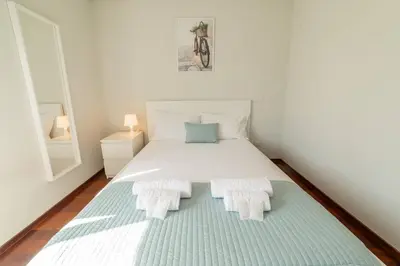 a bedroom with a white bed with two pillows at Modern Cedofeita by Hosty in Porto