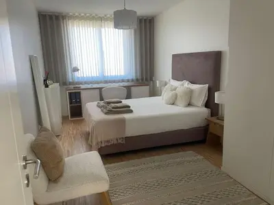 a bedroom with a large bed and a chair at Amazing Penthouse with a Terrace in Porto