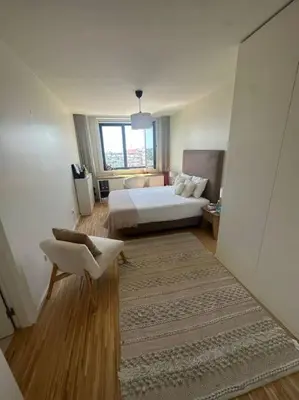 a bedroom with a bed and a chair and a window at Amazing Penthouse with a Terrace in Porto