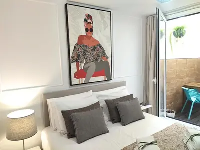 a bedroom with a bed with a painting above it at Cais das Pedras Pátio Apartment - with washer and dryer machine in Porto