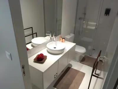 a white bathroom with two sinks and a shower at Cais das Pedras Pátio Apartment - with washer and dryer machine in Porto