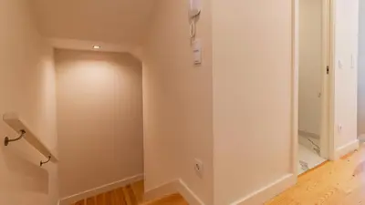 a hallway with white walls and wooden flooring at Delightful Duplex by LovelyStay in Porto