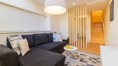 a living room with a couch and a table at Delightful Duplex by LovelyStay in Porto