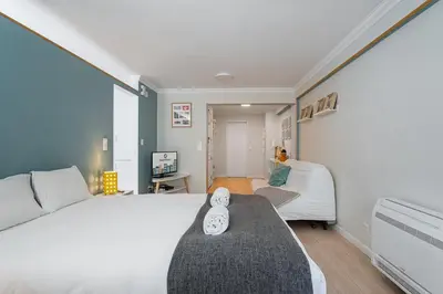 a bedroom with a large white bed and a couch at GuestReady - Porto by Pilar Ridge in Vila Nova de Gaia