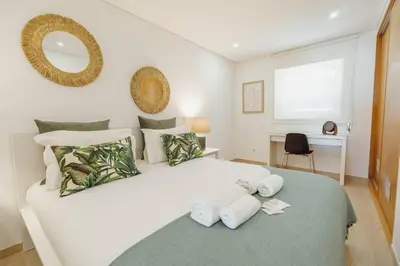a bedroom with a large white bed with towels on it at Stylish Apartment With Terrace by Hosty in Porto