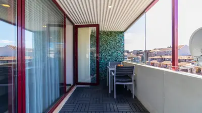 a balcony with a table and some glass windows at Abadia by LovelyStay in Porto