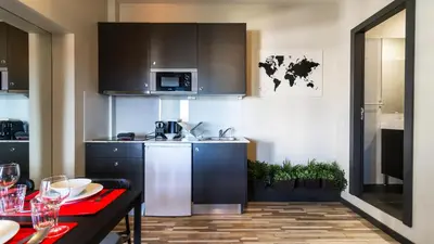 a kitchen with a refrigerator and a table with wine glasses at Abadia by LovelyStay in Porto