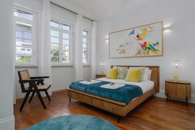 a bedroom with a bed and a desk and two windows at Romantic Luxury House w Captivating Outdoor Patio in Porto