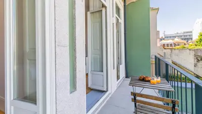 a balcony with a table and an open door at Duque Flat - AC & Balcony by LovelyStay in Porto