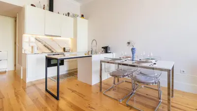 a kitchen with a table and two stools at Duque Flat - AC & Balcony by LovelyStay in Porto