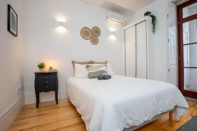 a white bedroom with a white bed and a window at Host Wise - Peaceful Amazing Apartment - Ace Location in Porto
