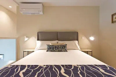 a bedroom with a large bed with a white bedspread at Ateneu Boutique Townhouse Bolhão in Porto