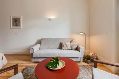 a living room with a red table and a couch at bnapartments Loftpuzzle in Porto