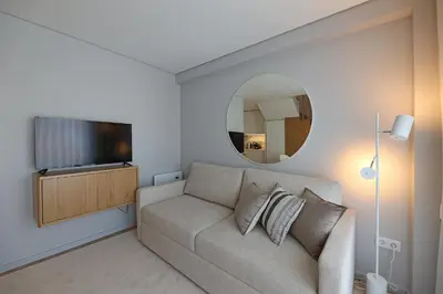 a living room with a couch and a mirror at FLH Boavista Wooden Duplexes in Porto