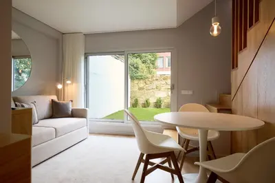 a living room with a table and a couch at FLH Boavista Wooden Duplexes in Porto
