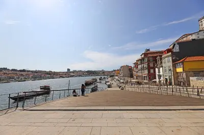 a pier next to a body of water with buildings at FLH Boavista Wooden Flats in Porto