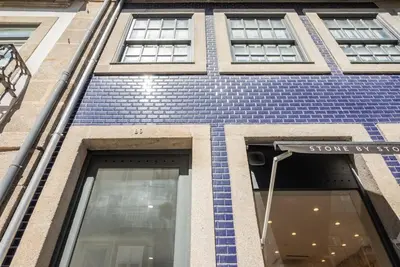 a blue brick building with a sign on it at Patio de Flores in Porto