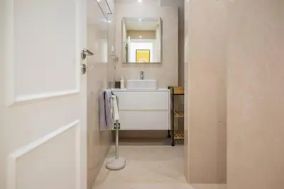 a bathroom with a white sink and a mirror at Patio de Flores in Porto