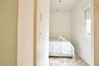 a white bedroom with a bed and a window at So Simply Ribeira in Porto