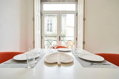 a white table with plates and glasses on it at So Simply Ribeira in Porto