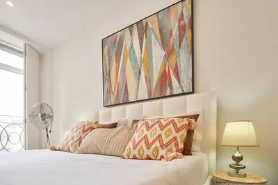 a bedroom with a bed and a painting on the wall at So Simply Ribeira in Porto