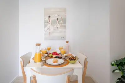 a white table with breakfast foods and orange juice at Host Wise - Peaceful Sunny Flat - Ace Location in Porto