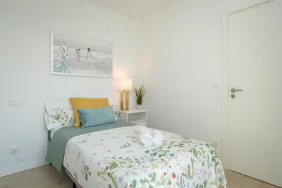 a white bedroom with a bed and a painting on the wall at Host Wise - Peaceful Sunny Flat - Ace Location in Porto
