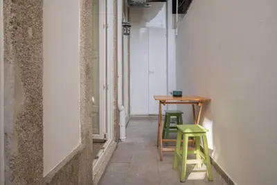 a small table and two green stools in a room at So Truly Porto in Porto