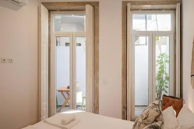 a bedroom with a bed and two glass doors at So Truly Porto in Porto