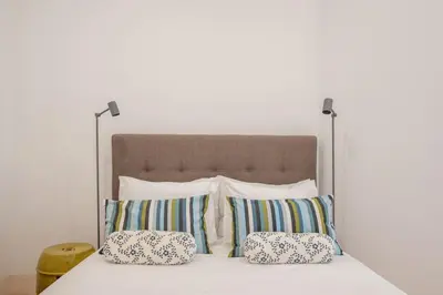 a bed with four pillows on top of it at So Truly Porto in Porto