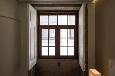 a window in a hallway with a stairway leading to a room at Mercadory Ribeira in Porto