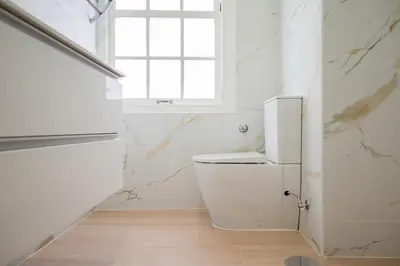 a white bathroom with a toilet and a window at Mercadory Ribeira in Porto