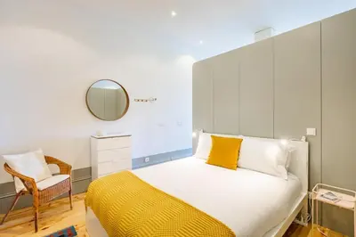 a bedroom with a bed with a mirror and a chair at Boavista Prime Studio in Porto